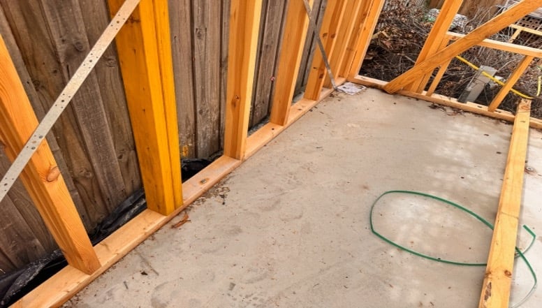 Timber frame of a house next to a concrete slab