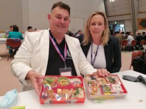 Man and lady holding bento boxes of Japanese food
