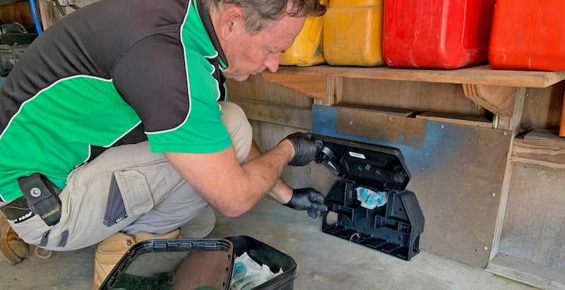 Pest control technician installing Generation FirstStrike, a soft bait for rodents