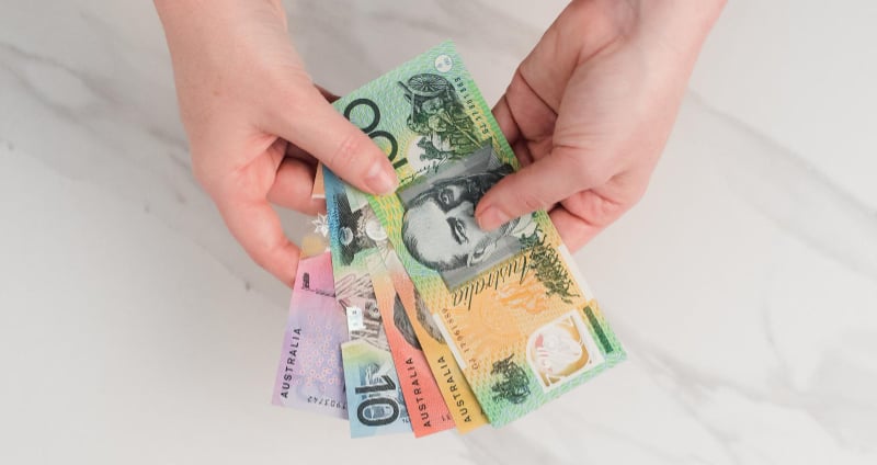 Caucasian hands holding Australian banknotes