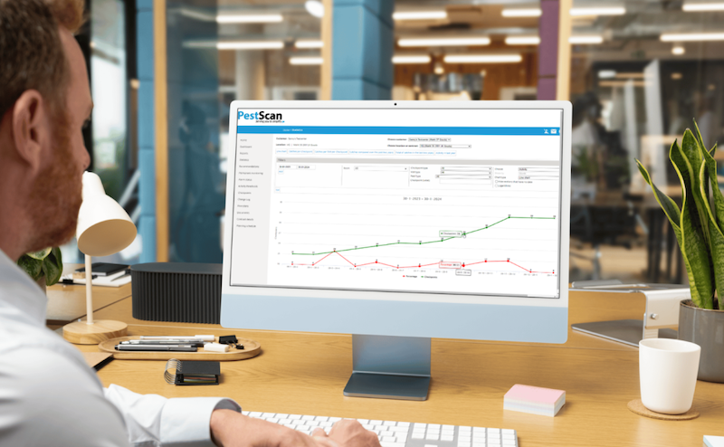 Man sitting at a desk with PestScan software showing on the screen