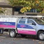 Pink Pest Control vehicle parked on a leafy street