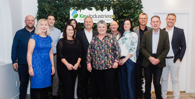 Group of people in front of a sign saying Key Industries Ltd