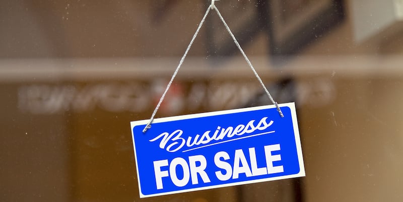 Blue sign in a window saying 'business for sale'