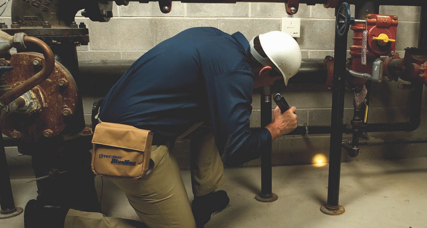 Man doing a pest inspection using a torch