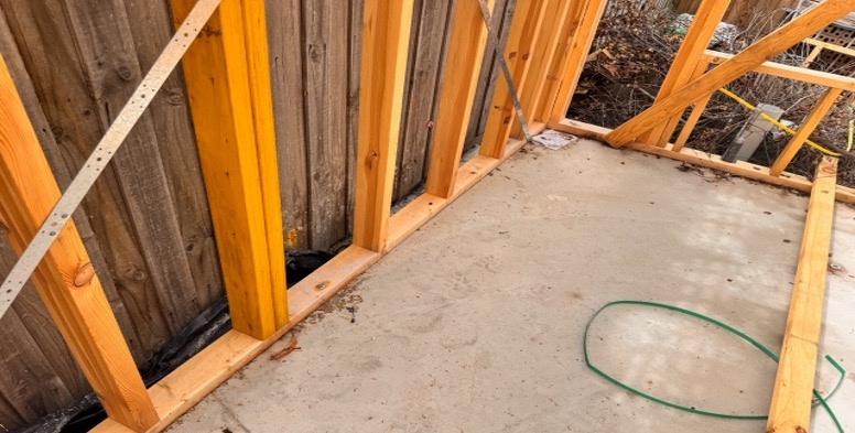 Timber frame of a house next to a concrete slab