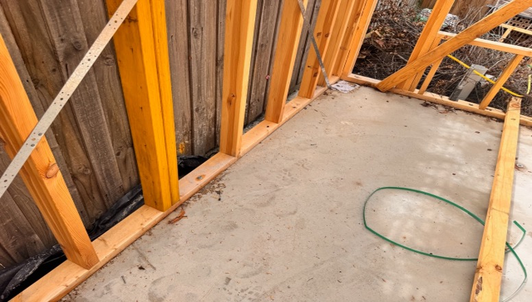 Timber frame of a house next to a concrete slab
